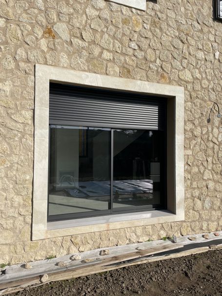 Parement en pierre brute tout venant avec encadrement en pierre sciée